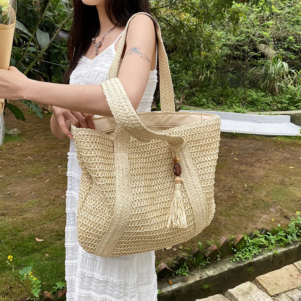 Handwoven straw summer tote bag with tassel accent, front view